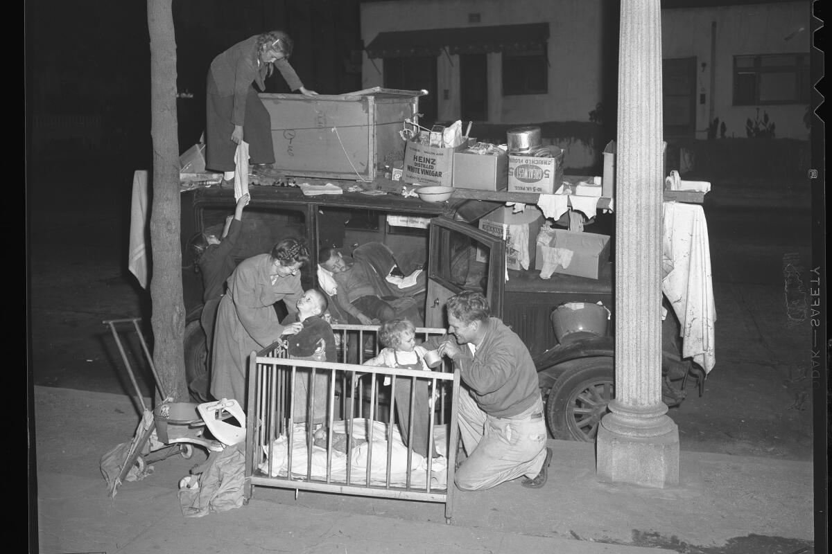 A homeless man and woman live with their children in a car in Los Angeles on Aug. 6, 1946.