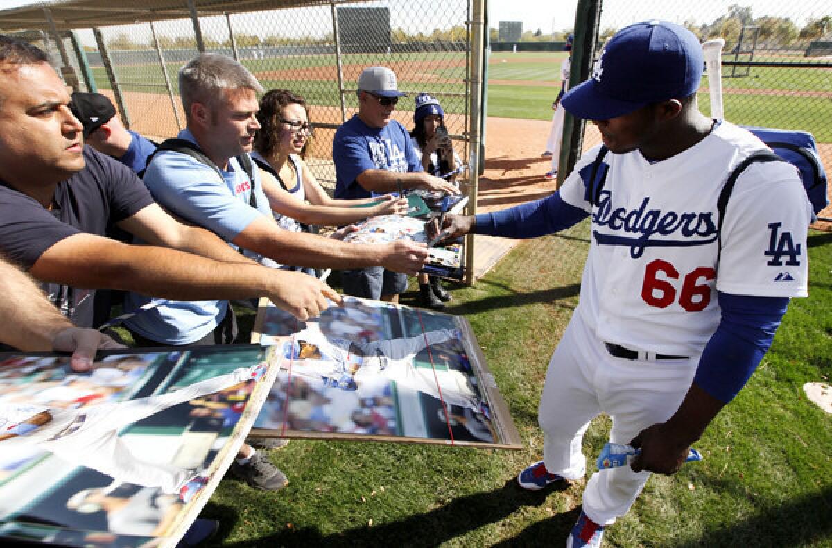 Fans get an autograph session with outfielder Yasiel Puig after the Dodgers completed a spring training workout last week at Camelback Ranch in Glendale, Ariz.