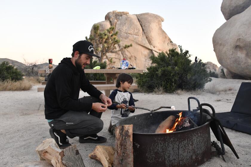 Father Cory and son Benjamin McPherson roast a marshmallow Wednesday night in the Hidden Valley campground at Joshua Tree National Park