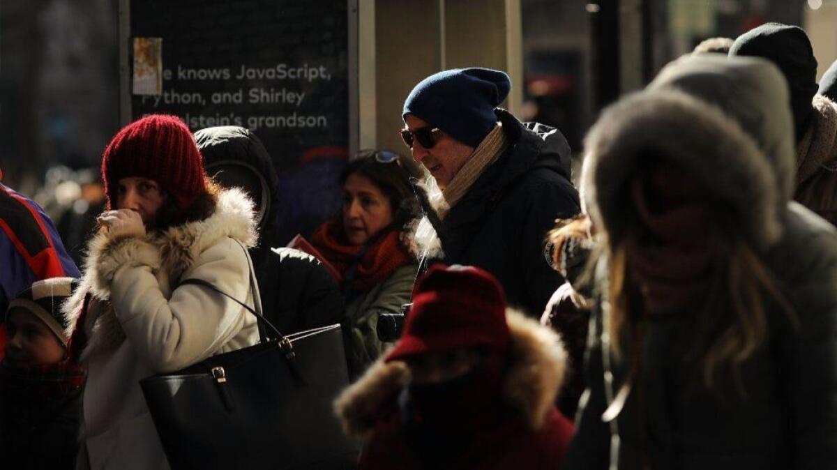 People walk through a frigid Manhattan in New York City on Thursday.