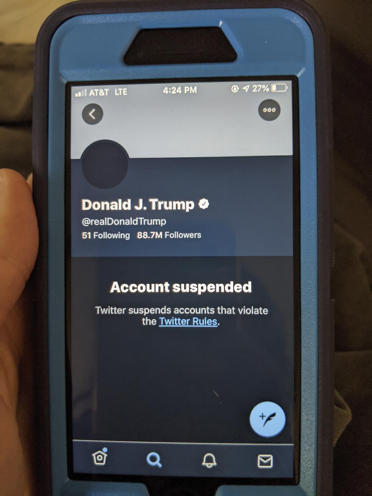 Un teléfono celular muestra la suspensión en Twitter de la cuenta del presidente Trump.
