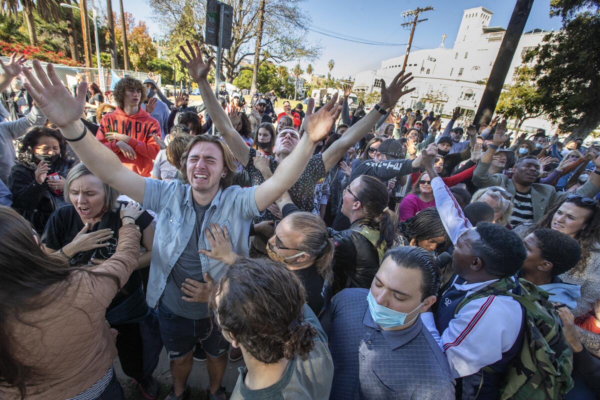 People pray, many without masks, at a Christian gathering at Echo Park Lake 