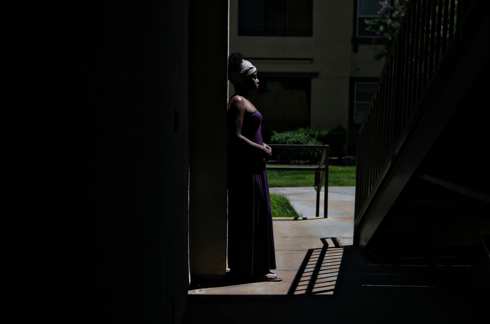 A woman standing in a walkway at an apartment
