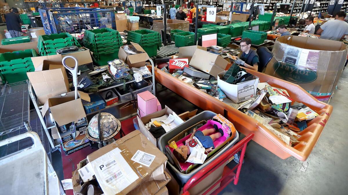 Program participants sort through and categorize donated items at a Goodwill of Orange County warehouse in Santa Ana.