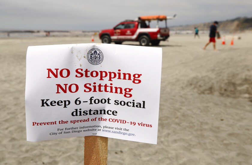 Sign at La Jolla Shores reminds people to practice social distancing.