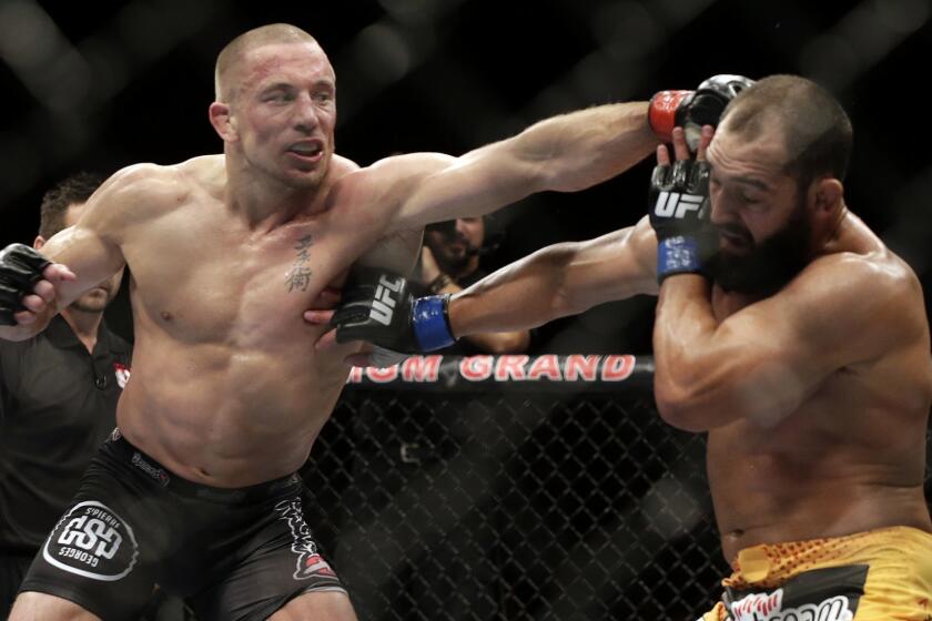 Johny Hendricks, right, exchanges punches with Georges St. Pierre, of Canada, during a UFC 167 mixed martial arts championship welterweight bout on Saturday, Nov. 16, 2013, in Las Vegas. St. Pierre won by split decision. (AP Photo/Isaac Brekken)
