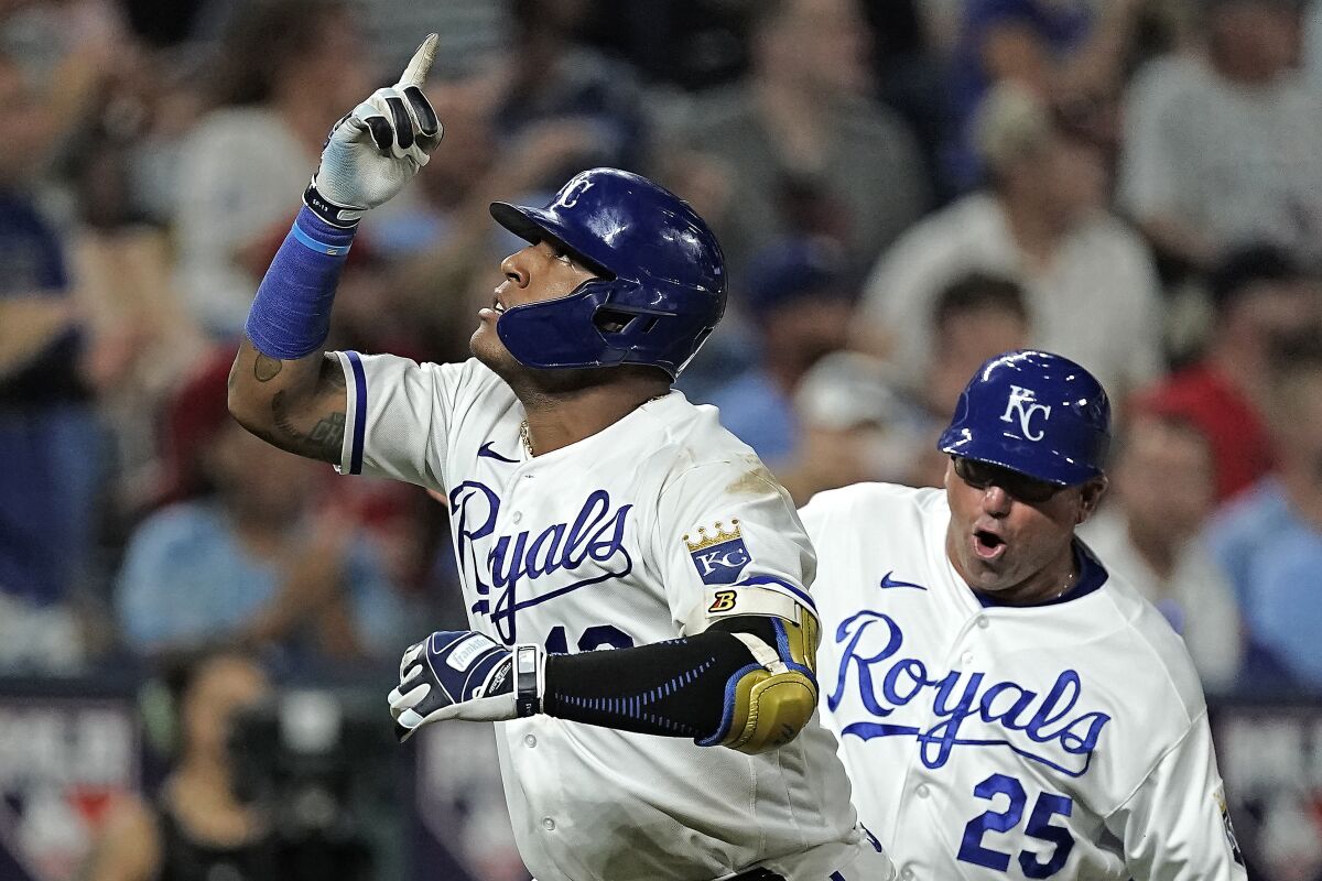 Kansas City Royals' Salvador Perez celebrates with third base coach Vance Wilson after hitting a three-run home run during the seventh inning of a baseball game against the Boston Red Sox Thursday, Aug. 4, 2022, in Kansas City, Mo. (AP Photo/Charlie Riedel)