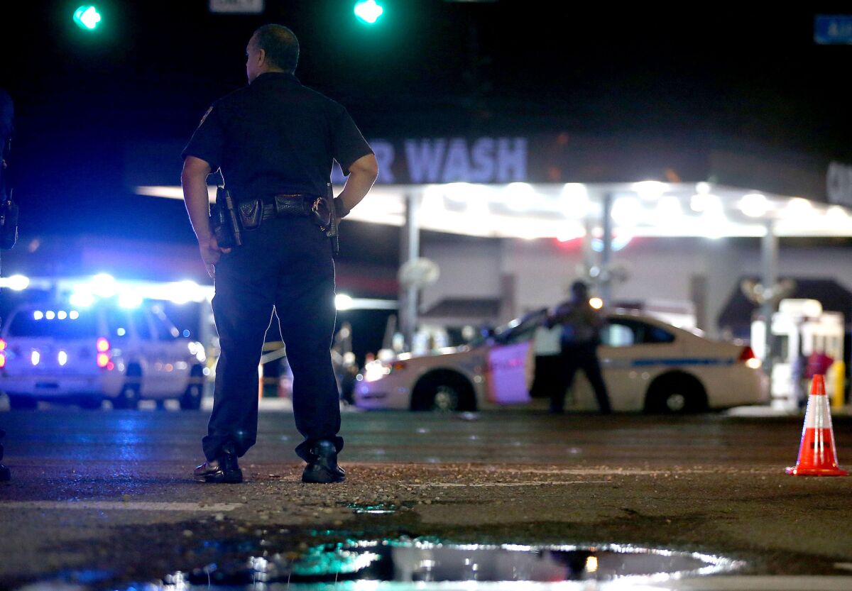 Police officers stand near the scene where three officers were killed on July 17 in Baton Rouge, La.