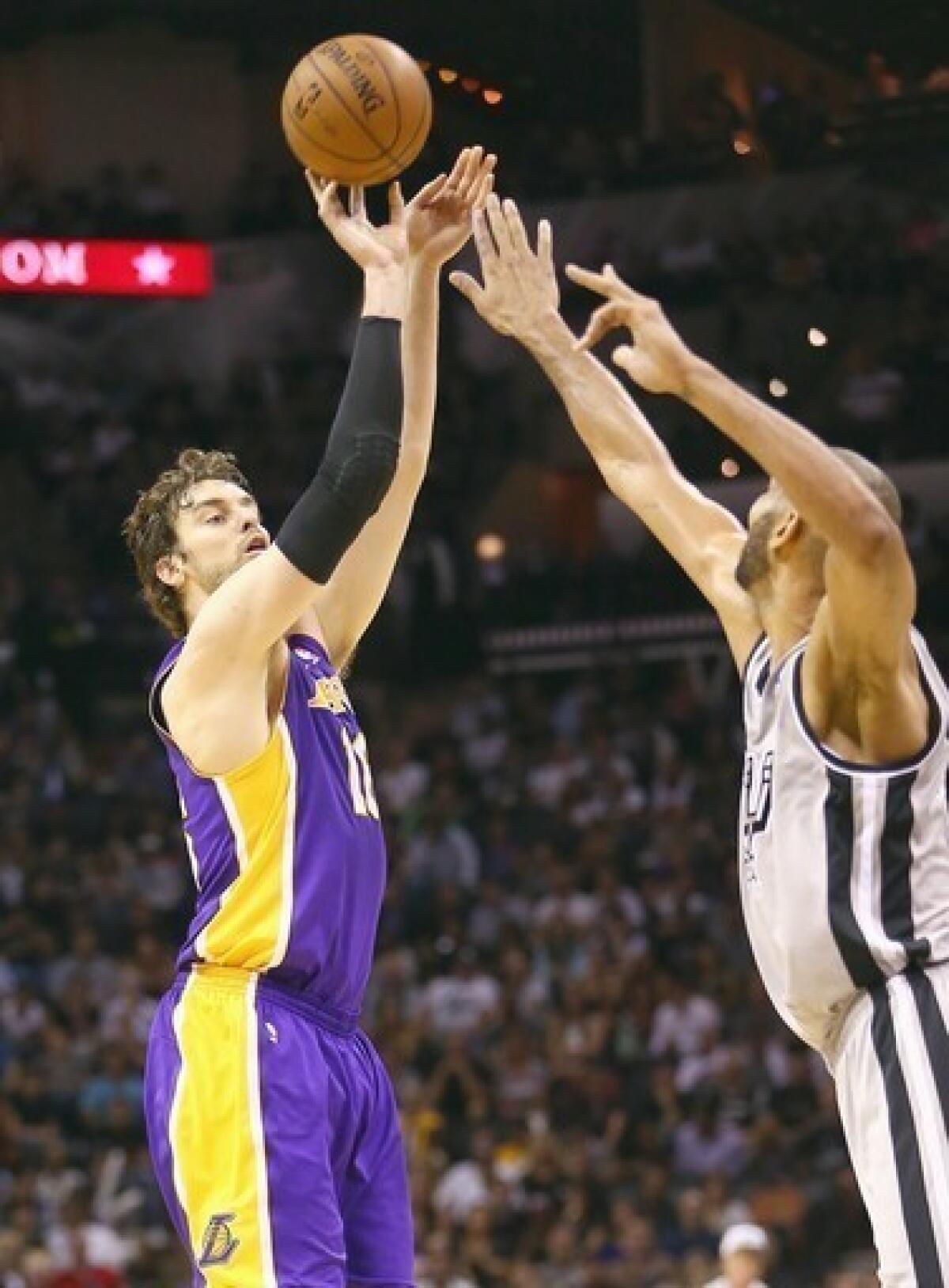Lakers power forward Pau Gasol puts up a shot over Spurs power forward Tim Duncan.