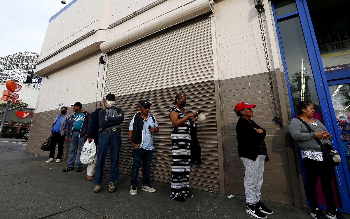 In April, people line up outside a store in Westlake, which has one of Los Angeles County's highest coronavirus infection rates and leads the nation in levels of overcrowded housing.
