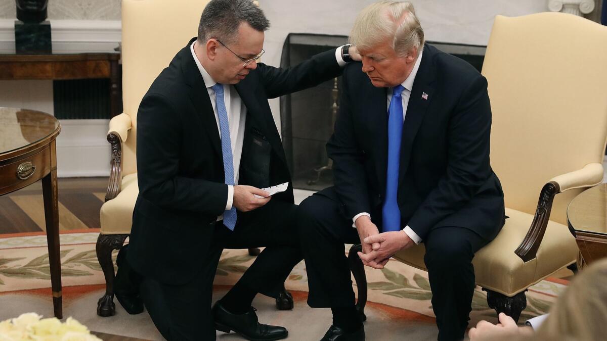 President Trump and evangelical Christian preacher Andrew Brunson participate in a prayer in the Oval Office on Saturday, a day after Brunson was released from a Turkish jail.