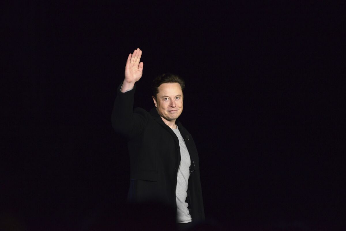FILE - Elon Musk waves while providing an update on SpaceX's Starship, Thursday, Feb. 10, 2022, near Brownsville, Texas. In April 2022, a group of Tesla shareholders suing Musk over some 2018 tweets about taking the company private is asking a federal judge to order him to stop commenting on the case. (Miguel Roberts/The Brownsville Herald via AP, File)
