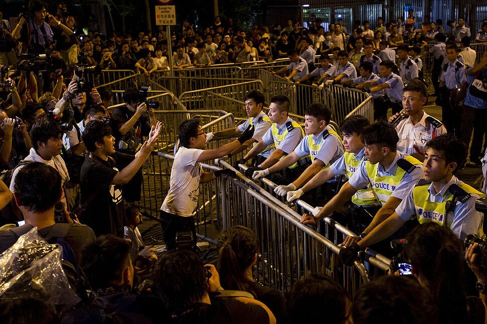 Pro-democracy demonstrators face policemen outside the Legislative Counsel office in Hong Kong. Protesters want the territory's Beijing-backed chief executive, Leung Chun-ying, to step down. He says he won't.