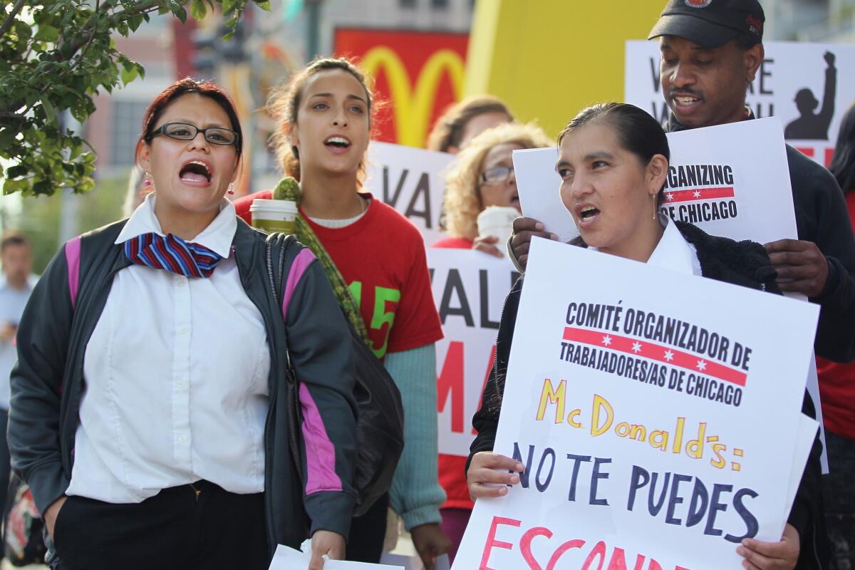 Fast food workers and activists demonstrate outside McDonald's downtown flagship restaurant on July 31 in Chicago. A bill recently passed by the California Legislature would give franchise operators more protection against improper termination by their chains, which supporters hope would help workers win higher wages.