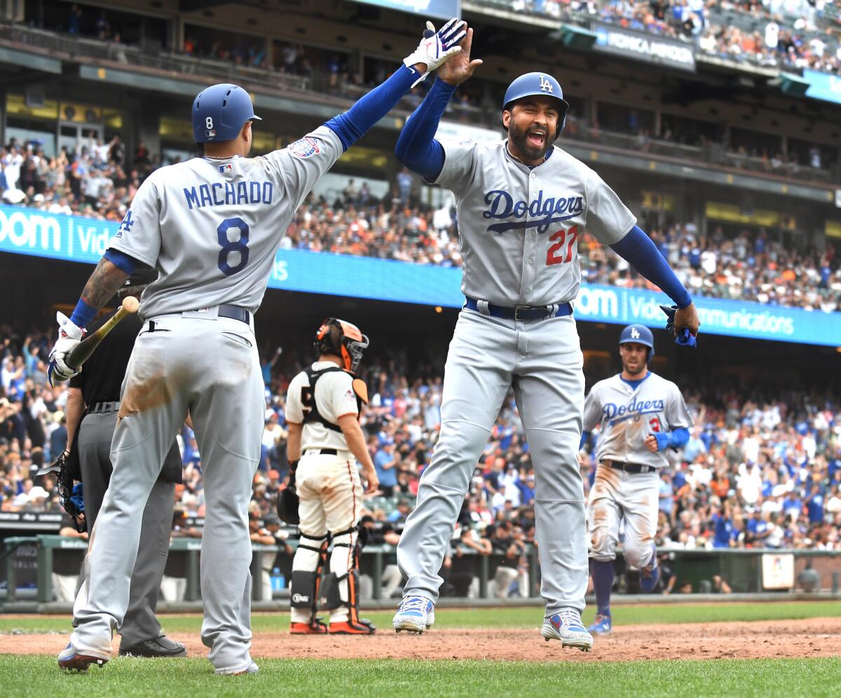 Dodgers' Matt Kemp (27) celebrates with Manny Machado after scoring a run against the San Francisco Giants at AT&T Park in San Francisco on Sept. 29.