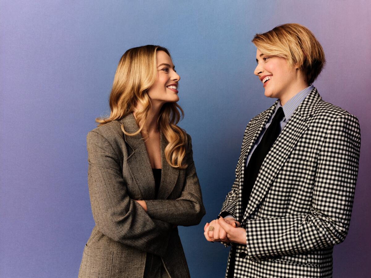 Margot Robbie and Greta Gerwig share a laugh during a photo shoot.