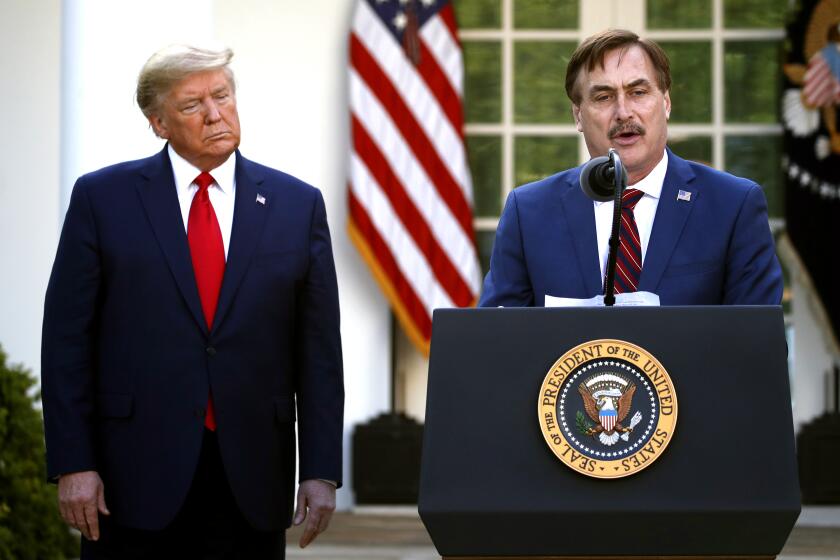 FILE - In this March 30, 2020 file photo, My Pillow CEO Mike Lindell speaks as President Donald Trump listens during a briefing about the coronavirus in the Rose Garden of the White House, in Washington. Lindell, an avid supporter of President Donald Trump, who has continued to push the notion of election fraud since Trump lost to Joe Biden in the presidential election in November, said his products will no longer be carried in the stores of some retailers, including Bed Bath & Beyond and Kohl's. (AP Photo/Alex Brandon, File)