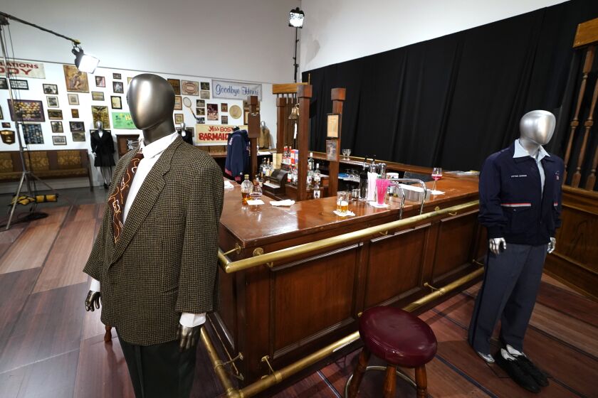 FILE - The bar used on the set of the television series "Cheers" and some costumes worn by actors on the sitcom are displayed, April 27, 2023, in Irving, Texas. The bar from the television series “Cheers” sold for $675,000 at auction over the weekend, garnering the highest bid among the nearly 1,000 props, costumes and sets from classic TV shows offered up from a collection amassed by one man over more than three decades. Heritage Auctions said that the items sold during its three-day event that wrapped up Sunday, June 4, 2023, in Dallas brought. (AP Photo/Tony Gutierrez, File)