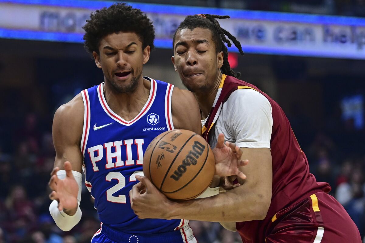Cleveland Cavaliers center Moses Brown, right, rebounds against Philadelphia 76ers guard Matisse Thybulle (22) in the first half of an NBA basketball game, Sunday, April 3, 2022, in Cleveland. (AP Photo/David Dermer)