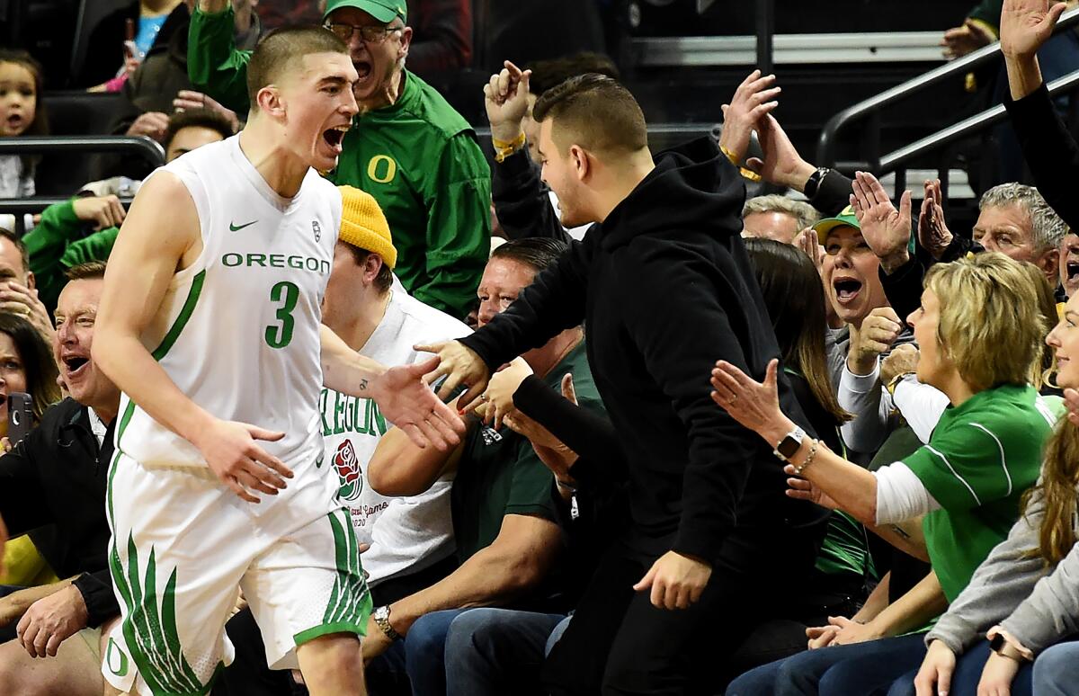 Oregon's Payton Pritchard celebrates with fans after hitting a shot during the first overtime against USC .