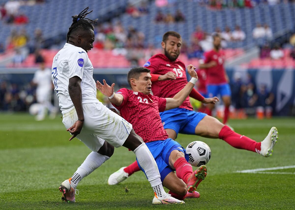 Costa Rica's Joseph Mora (22) and Francisco Calvo (15) block a shot by Honduras' Alberth Elis.