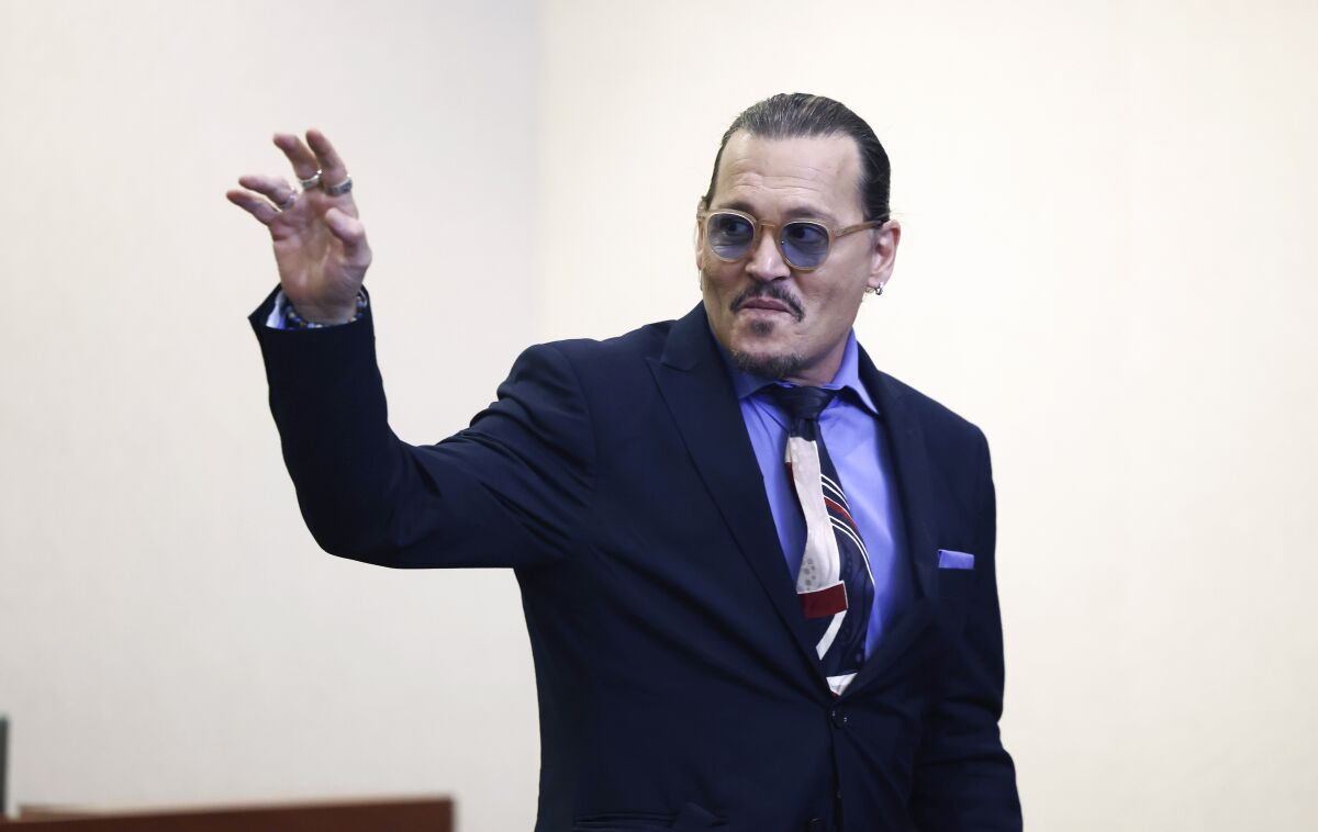 Actor Johnny Depp waves as he leaves the courtroom for a recess at the Fairfax County Circuit Court in Fairfax, Va., Thursday, May 5, 2022. Depp sued his ex-wife actor Amber Heard for libel in Fairfax County Circuit Court after she wrote an op-ed piece in The Washington Post in 2018 referring to herself as a "public figure representing domestic abuse." (Jim Lo Scalzo/Pool Photo via AP)