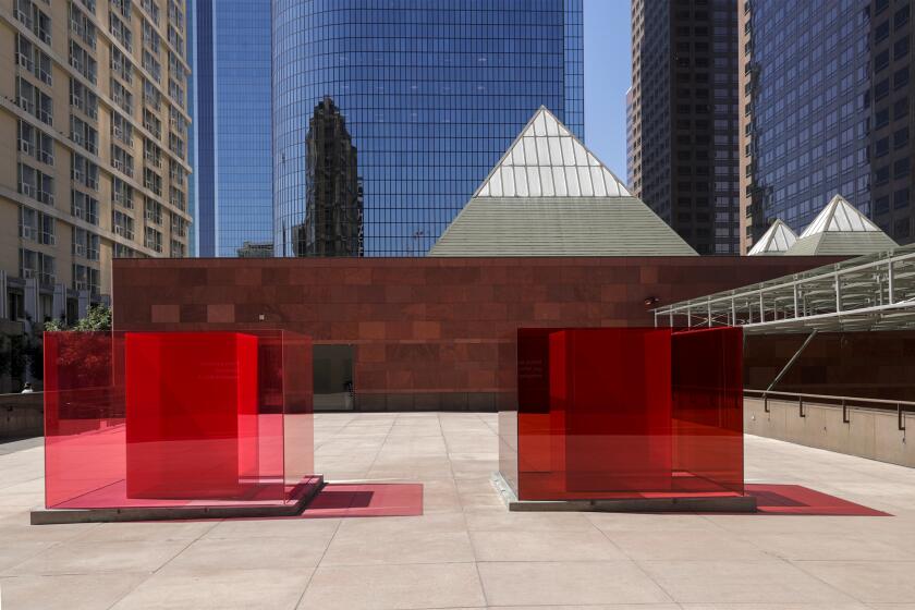 Two transparent red cubes, an art installation by Larry Bell, sit outside the Museum of Contemporary Art in downtown L.A. 
