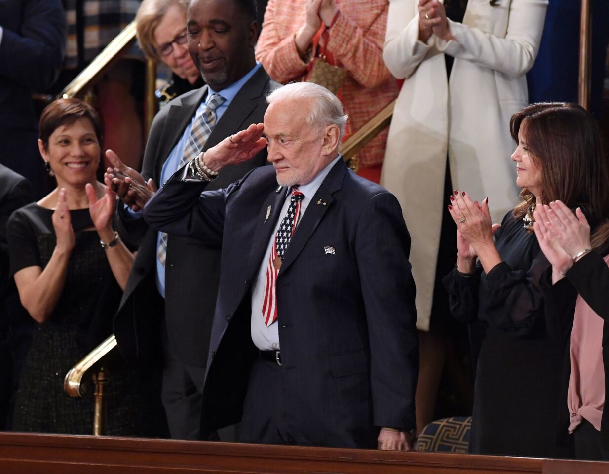 Former NASA astronaut Buzz Aldrin salutes as he is recognized by the president.