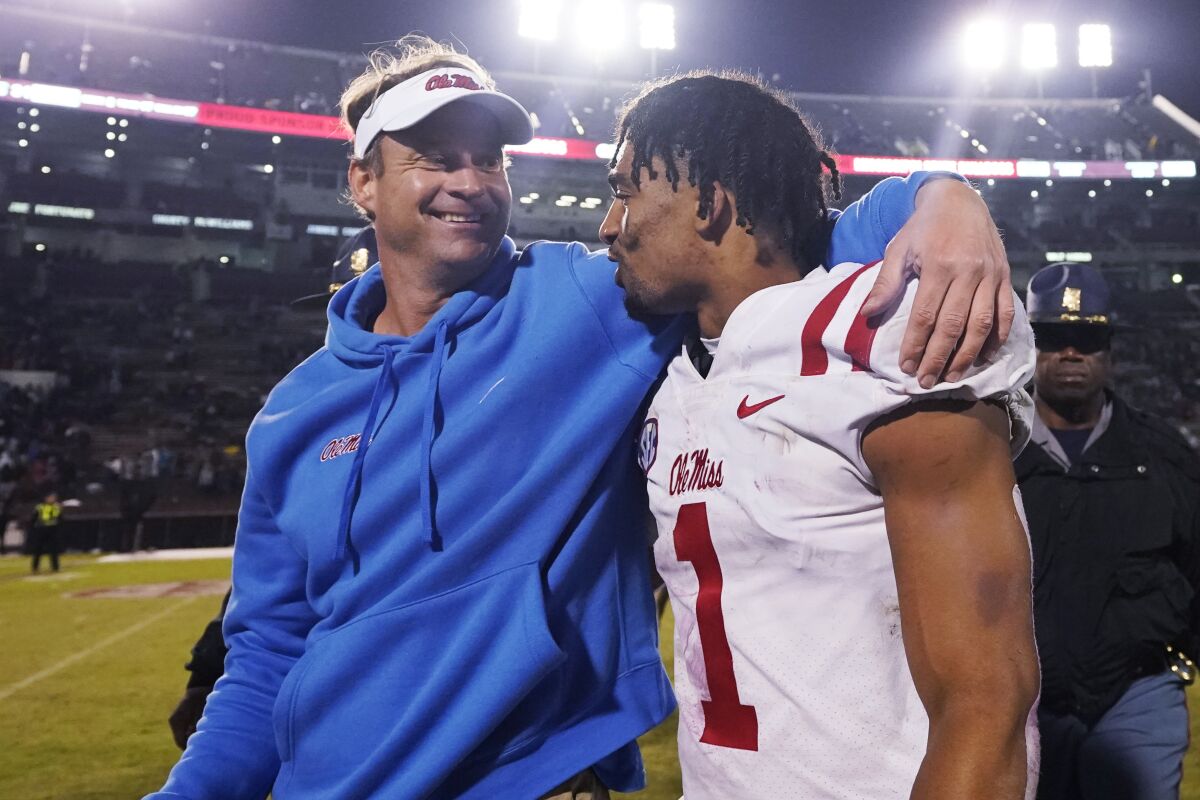 Mississippi coach Lane Kiffin talks with defensive back Jake Springer following the team's NCAA college football game against Mississippi State, Thursday, Nov. 25, 2021, in Starkville, Miss. Mississippi won 31-21. (AP Photo/Rogelio V. Solis)