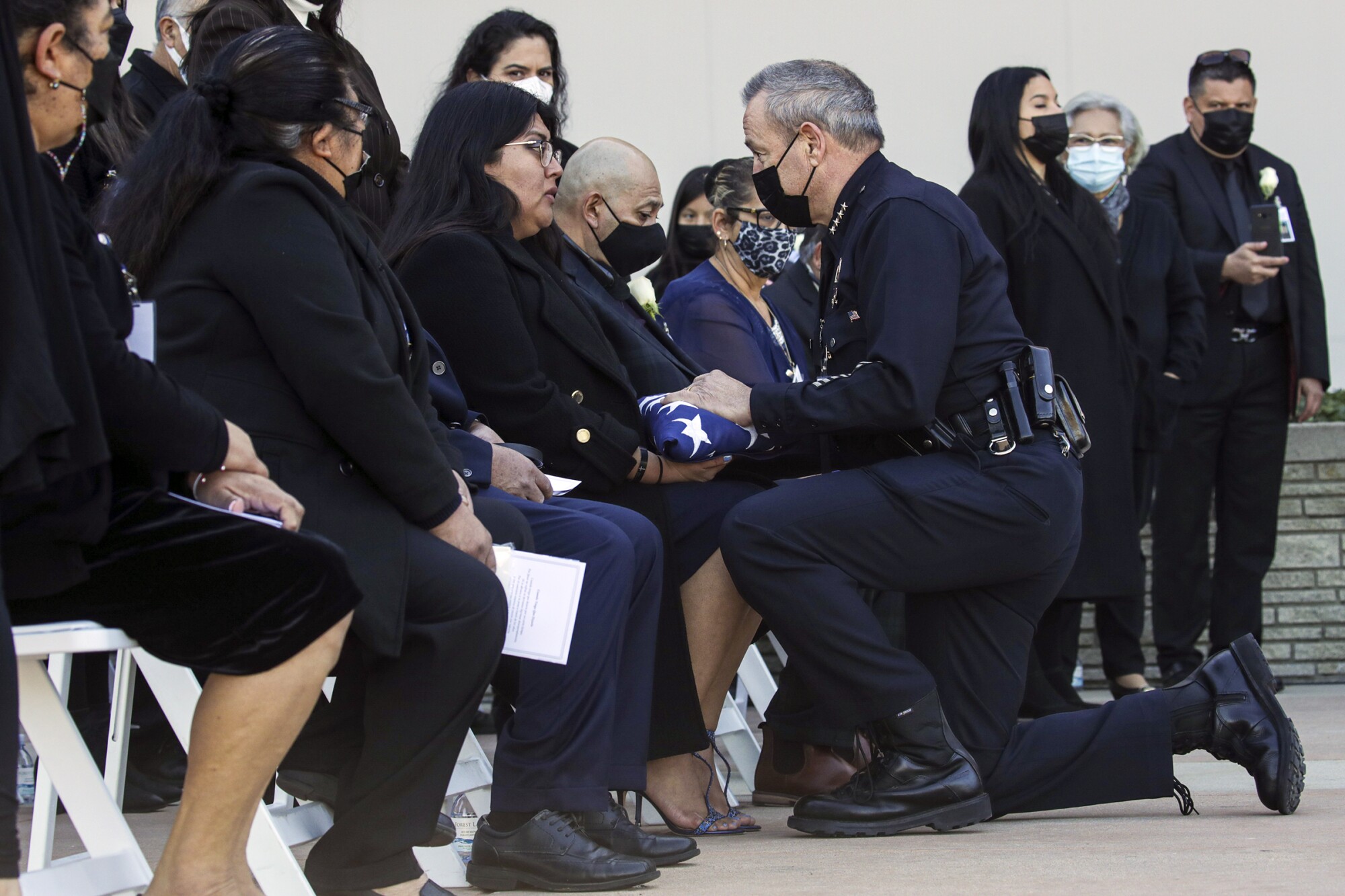 LAPD Chief Michel Moore, right, presents a flag to Angela Mendoza, girlfriend of fallen LAPD Officer Fernando Arroyos.