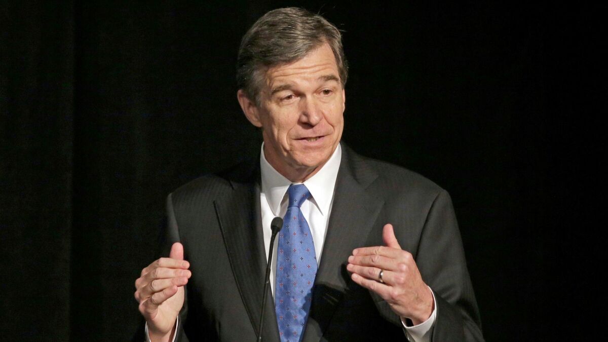In a June 2016 file photo, then-North Carolina Atty. Gen. Roy Cooper speaks during a forum in Charlotte, N.C.
