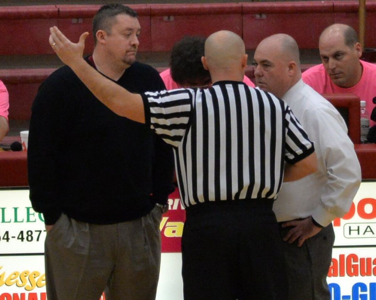 A referee talks to Riverdale Coach Cory Barrett, left, and Smyrna Coach Shawn Middleton during a Feb. 21 high school basketball game in Murfreesboro, Tenn.
