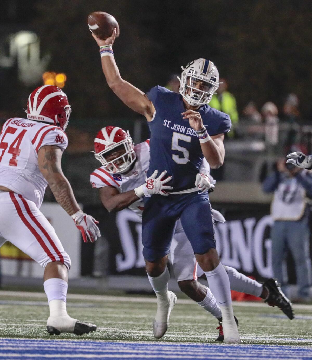 Mater Dei defenders pressure St. John Bosco quarterback DJ Uiagalalei during the Southern Section Division 1 championship game Nov. 30, 2019, at Cerritos College.