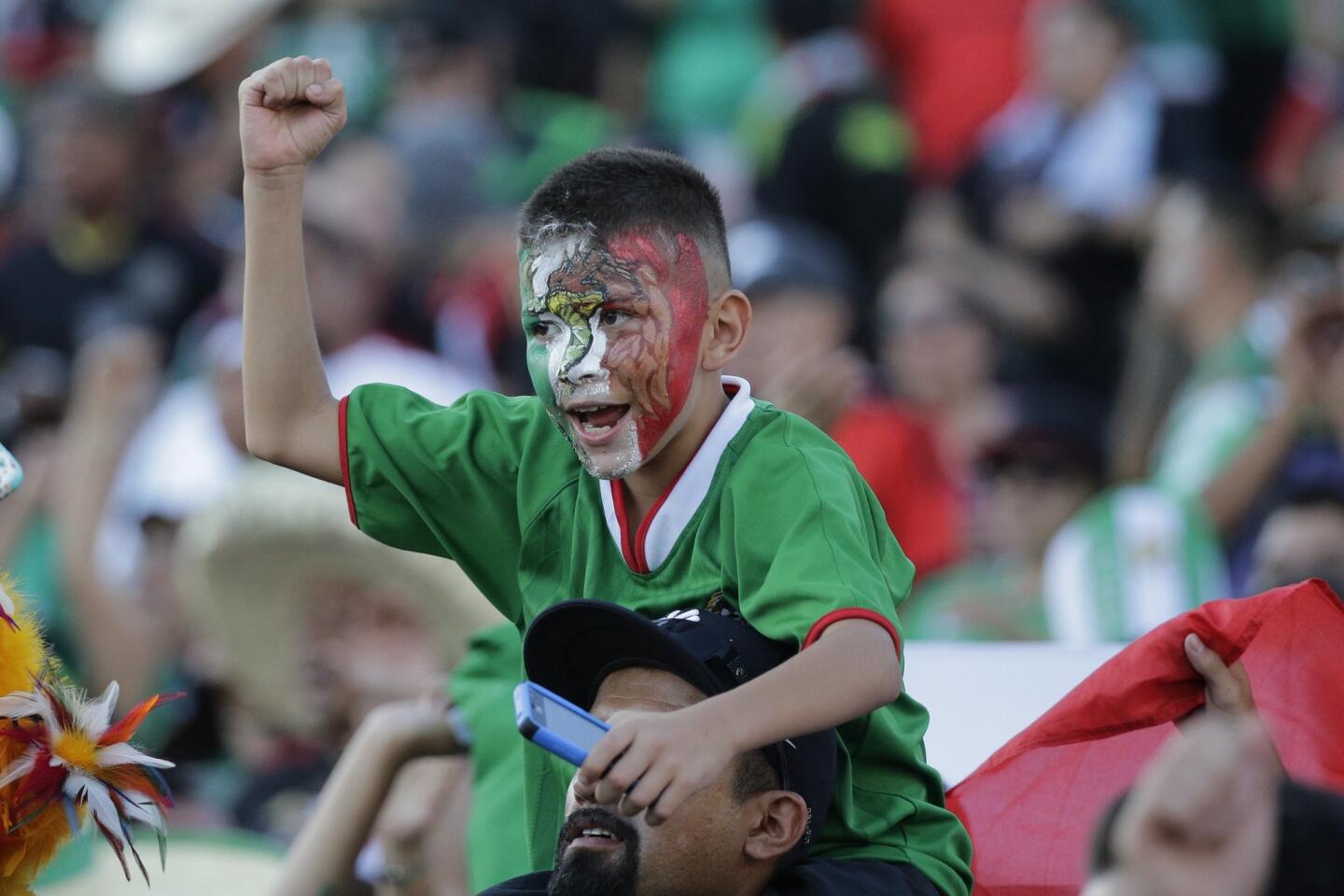 A young fan of Mexico cheers prior to the CONCACAF Confederations Cup playoff soccer match between Mexico and United States at the Rose Bowl Stadium, in Pasadena , Calif. Saturday, Oct. 10, 2015, (AP Photo/Jae C. Hong)