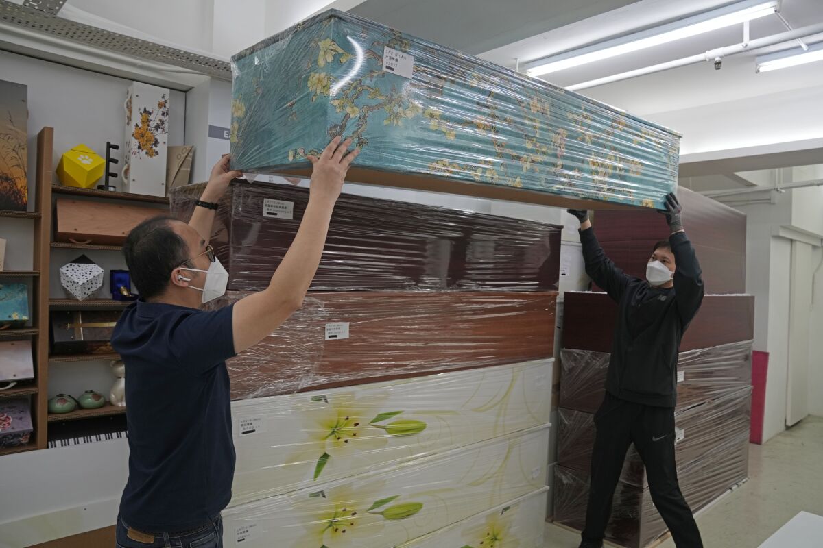 Workers move a coffin.