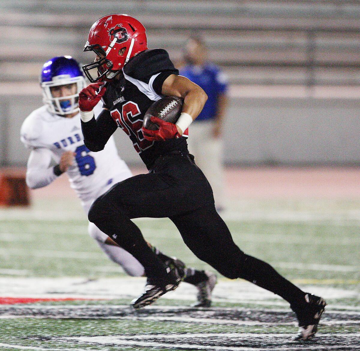 Glendale's Daniel Jung runs the ball past Burbank defender Nick Warren during a game on Thursday, October 16, 2014. Jung was recently named the team's most valuable player.