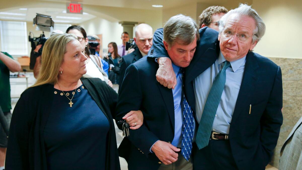 Shannon Kepler, center, walks with his wife, Gina and attorney, Richard O'Carroll, after a hung jury verdict was announced Friday in Tulsa, Okla.