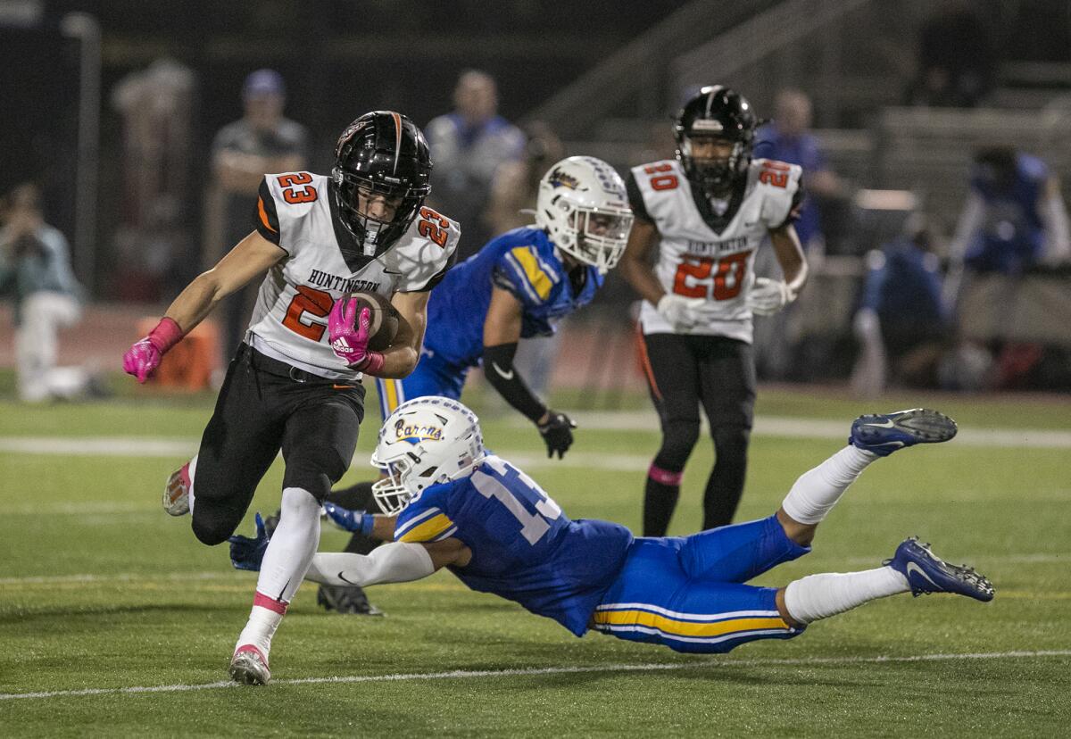 Huntington Beach's Tyler Young avoids a tackle by Fountain Valley's Nolan Olivares on his way to a touchdown on Friday.