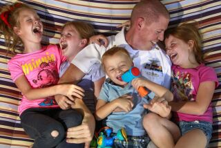SAN DIEGO, June 13, 2017 | Navy Chief Petty Officer Johnathon Stone with his children, from left, Allison, 9, twin sister Alyssa, adopted son Jackson, 4, and Madelynn, 7, while on the backyard hammock at their Pacific Beach home on Tuesday. | Photo by Hayne Palmour IV/San Diego Union-Tribune/Mandatory Credit: HAYNE PALMOUR IV/SAN DIEGO UNION-TRIBUNE/ZUMA PRESS San Diego Union-Tribune Photo by Hayne Palmour IV copyright 2017