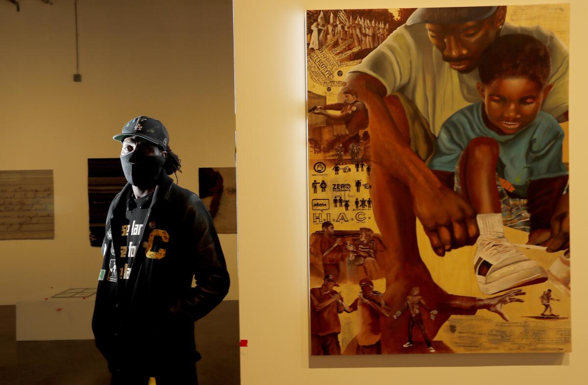 ShowzArt stands beside his untitled artwork at the We Rise pop-up gallery in downtown L.A.