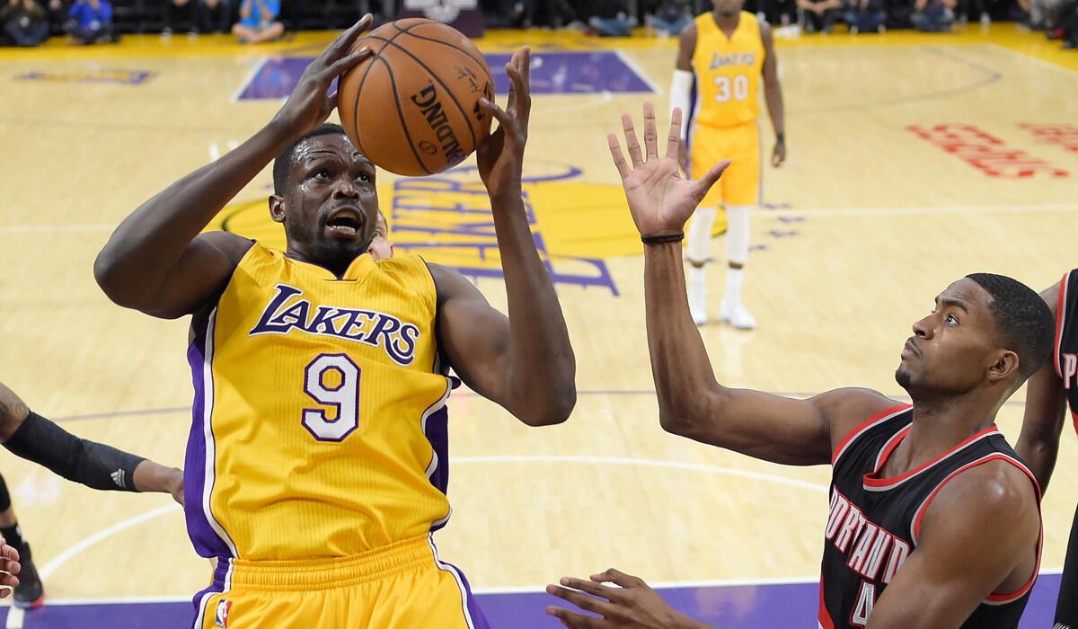 Lakers forward Luol Deng, left, grabs a rebound away from Portland Trail Blazers forward Maurice Harkless during the first half Tuesday.