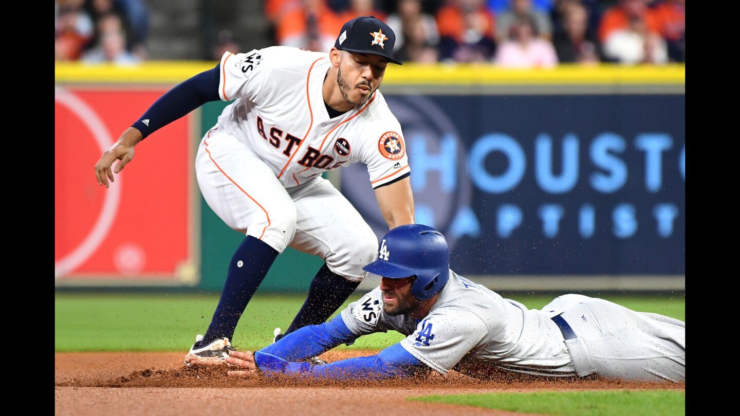The Dodgers' Chris Taylor is tagged out by Astros shortstop Carlos Carrea while trying to steal second base in the first inning.