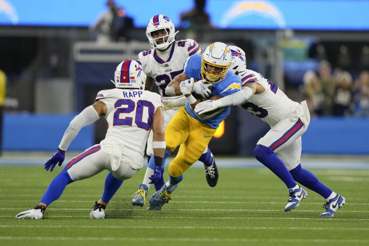 Chargers running back Austin Ekeler is tackled by Bills players during the second half.