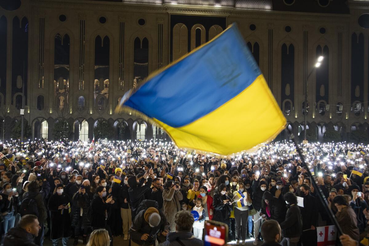 A crowd of people holding up lights with the Ukrainian flag