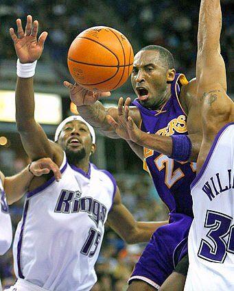 Kobe Bryant passes the ball between Sacramento Kings defenders John Salmons, left, and Corliss Williamson.