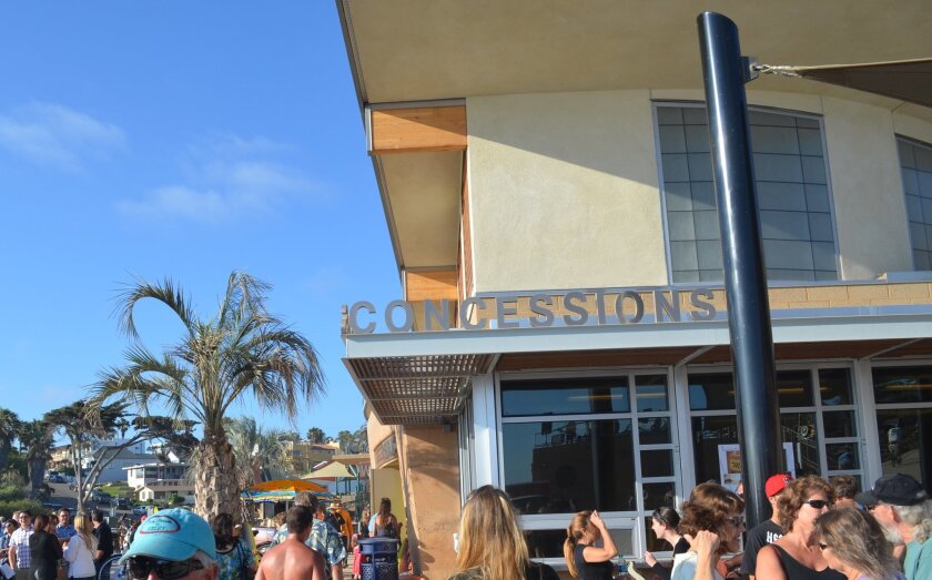 Beach-goers gather around the Moonlight Beach concession stand. A San Diego Superior Court judge recently sided with the city of Encinitas over a stand contract dispute.