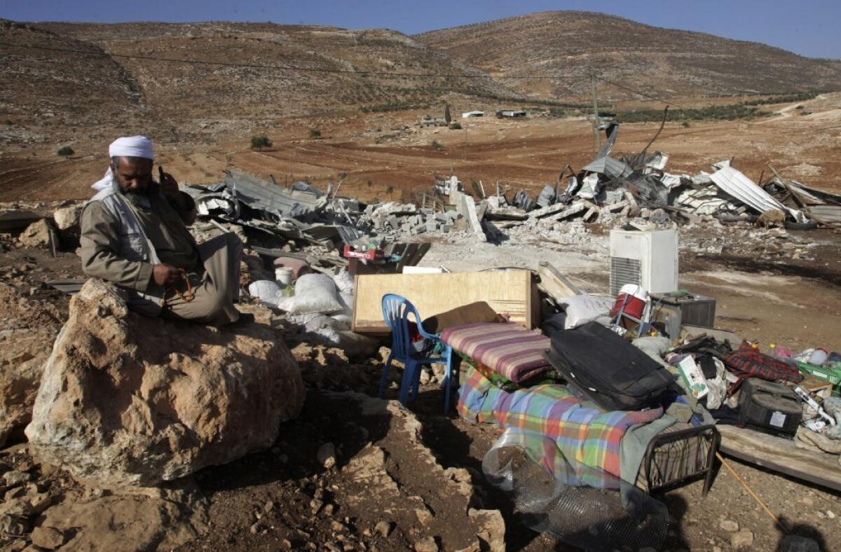 A Palestinian man sits by the remains of his house destroyed last month in Aqraba village near the West Bank city of Nablus. The Israeli military said it demolished four structures that had been built illegally in the village.