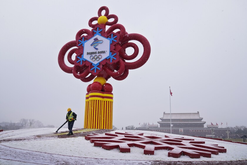  Un trabajador utiliza maquinaria para retirar la nieve de un adorno alusivo a los Juegos Olímpicos de Invierno