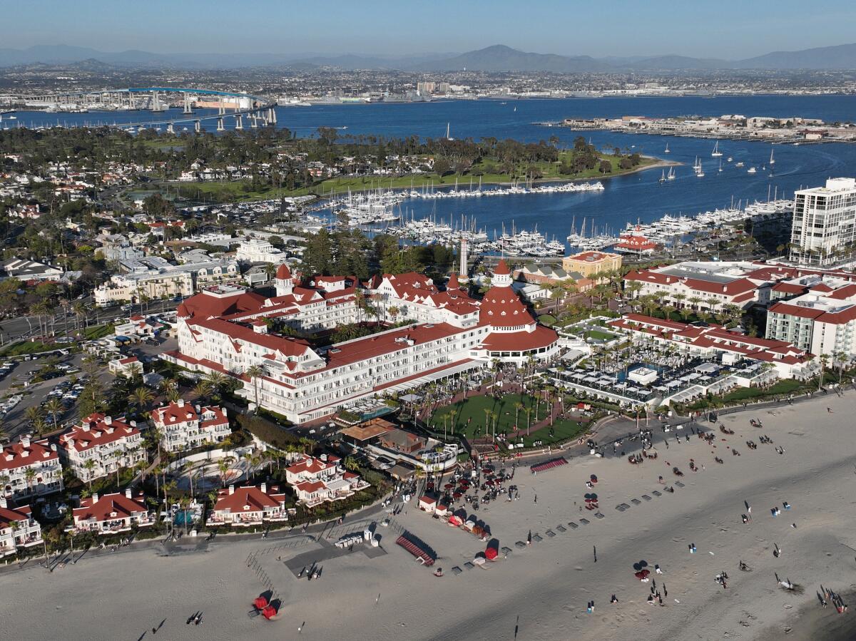 An aerial view of red-roofed buildings and sand.