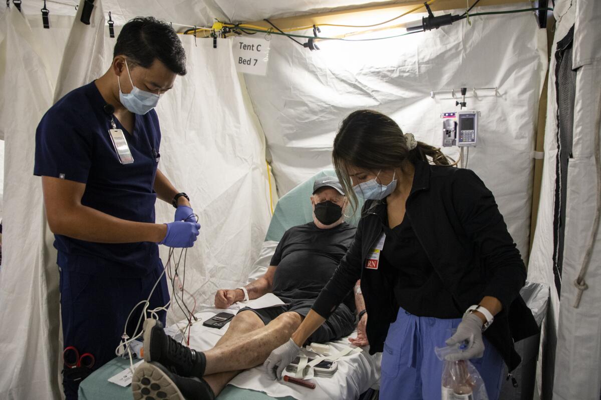 A patient is tended to in an overflow tent at Scripps Memorial Hospital Encinitas.